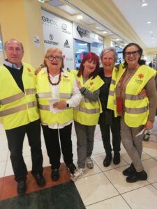 foto di gruppo di 5 persone sorridenti all'interno di un centro commerciale