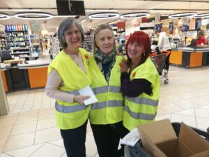 tre donne sorridenti all'interno di un supermercato